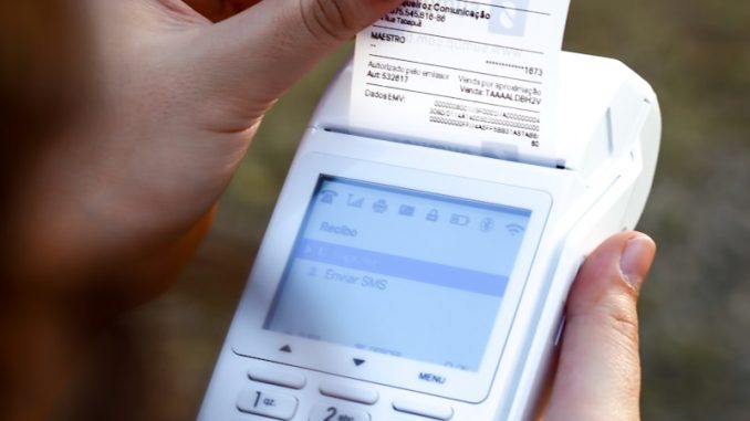 a person holding a cell phone and a receipt
